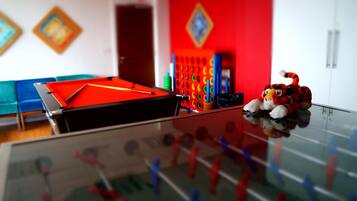 Enjoy a game of foosball in this stylish room with a glass table and modern decor.