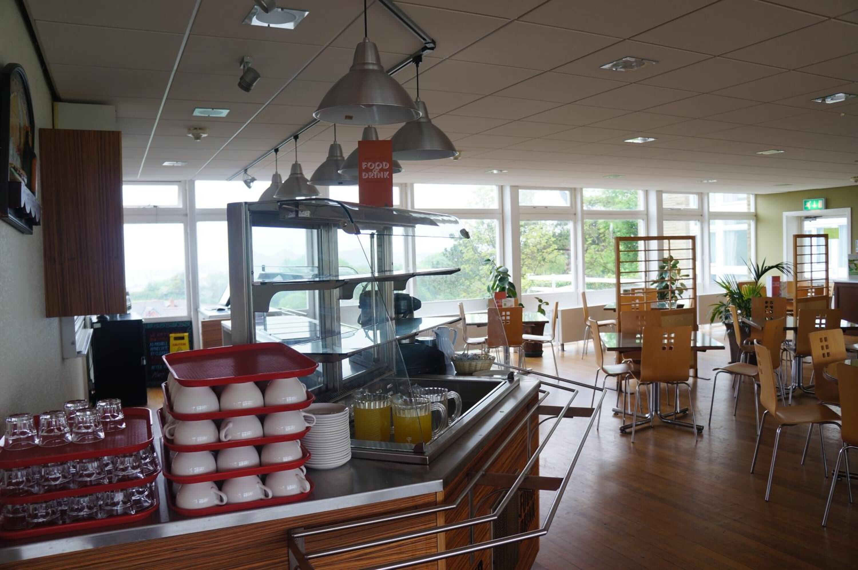 A buffet area with a food station, dining tables, and chairs.