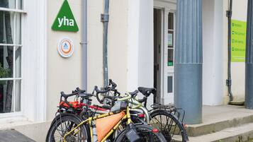 Un edificio con un cartel que dice "yha" y una señal de recepción. Hay bicicletas estacionadas afuera.