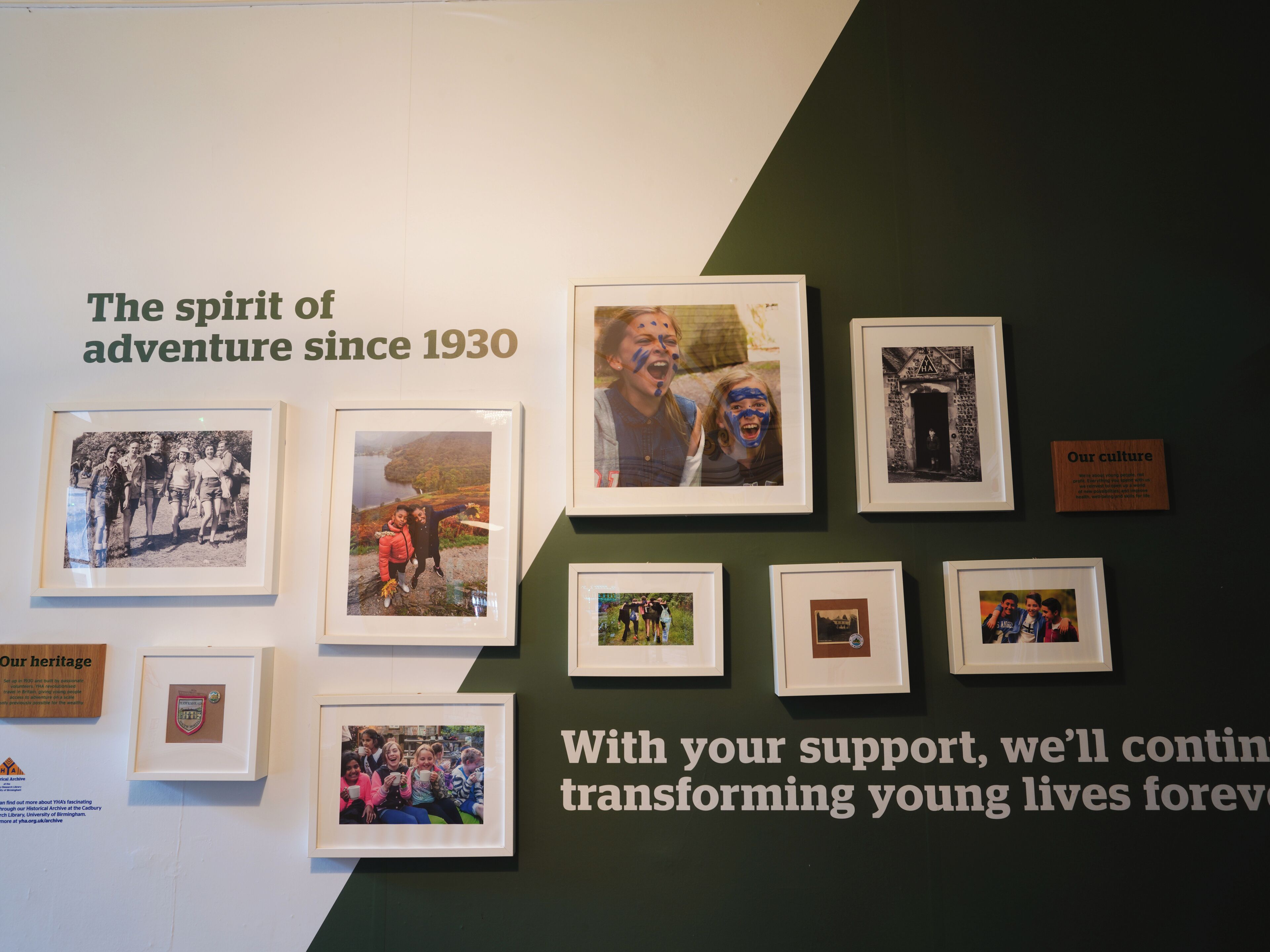 Un mur orné de photographies encadrées et de textes.