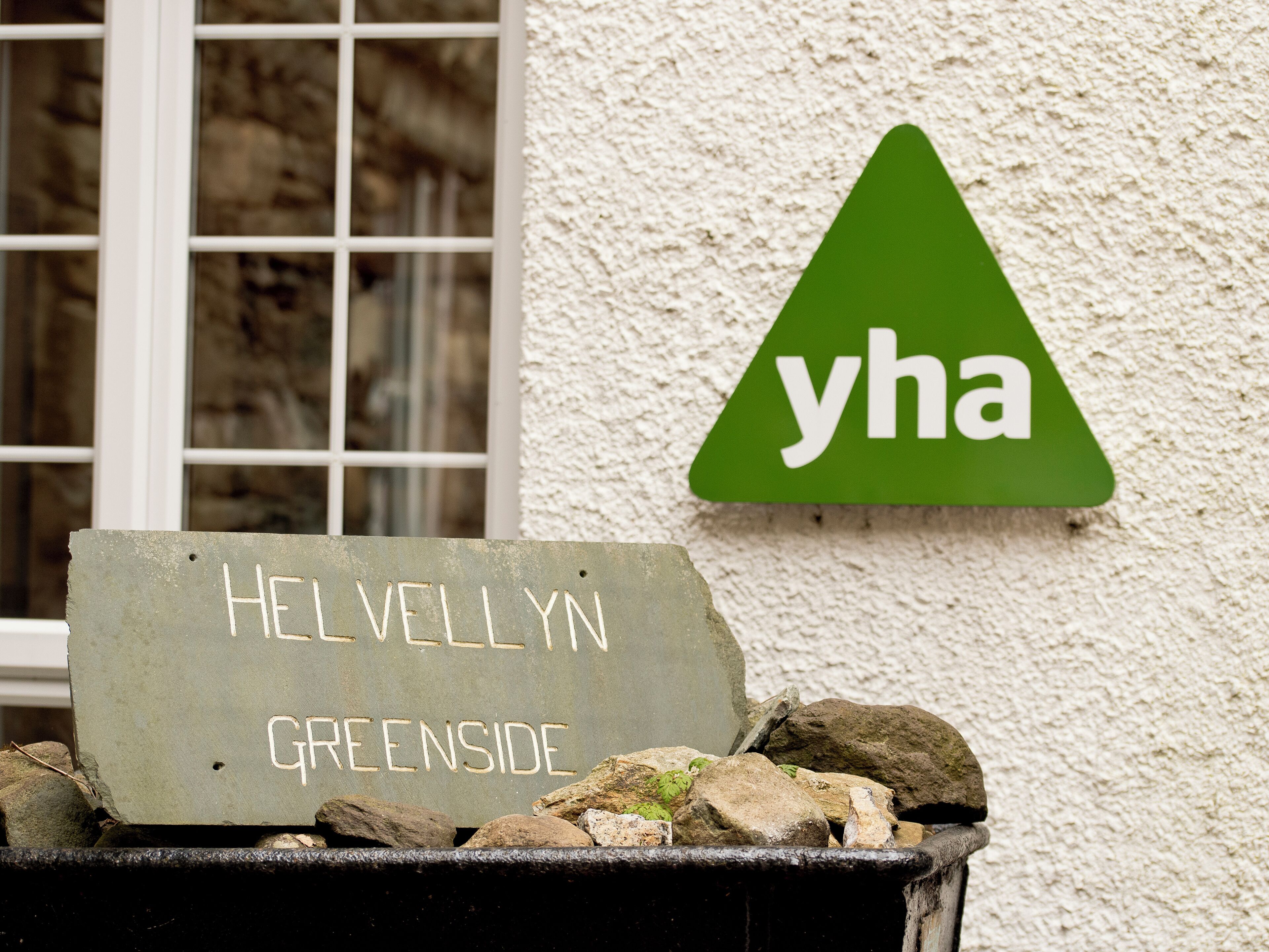 A sign for 'Helvellin Greenside' and a 'yha' logo on a wall.