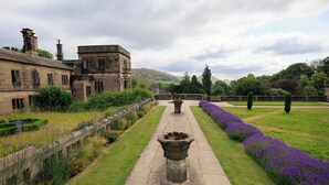 A stone pathway leading through a garden with a building on one side. - YHA Ilam Hall - Hostel (Ashbourne)