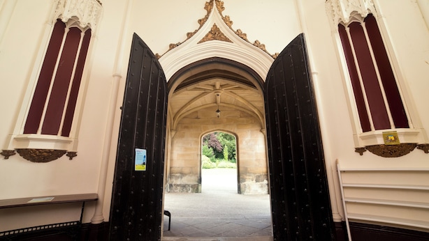 A corridor with high, ornate ceilings and large, dark wooden doors. - YHA Ilam Hall - Hostel (Ashbourne)