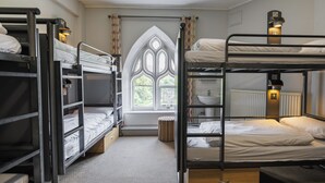 A bunk bed room with a window, a radiator, and a bedside table with a lamp. - YHA Ilam Hall - Hostel (Ashbourne)