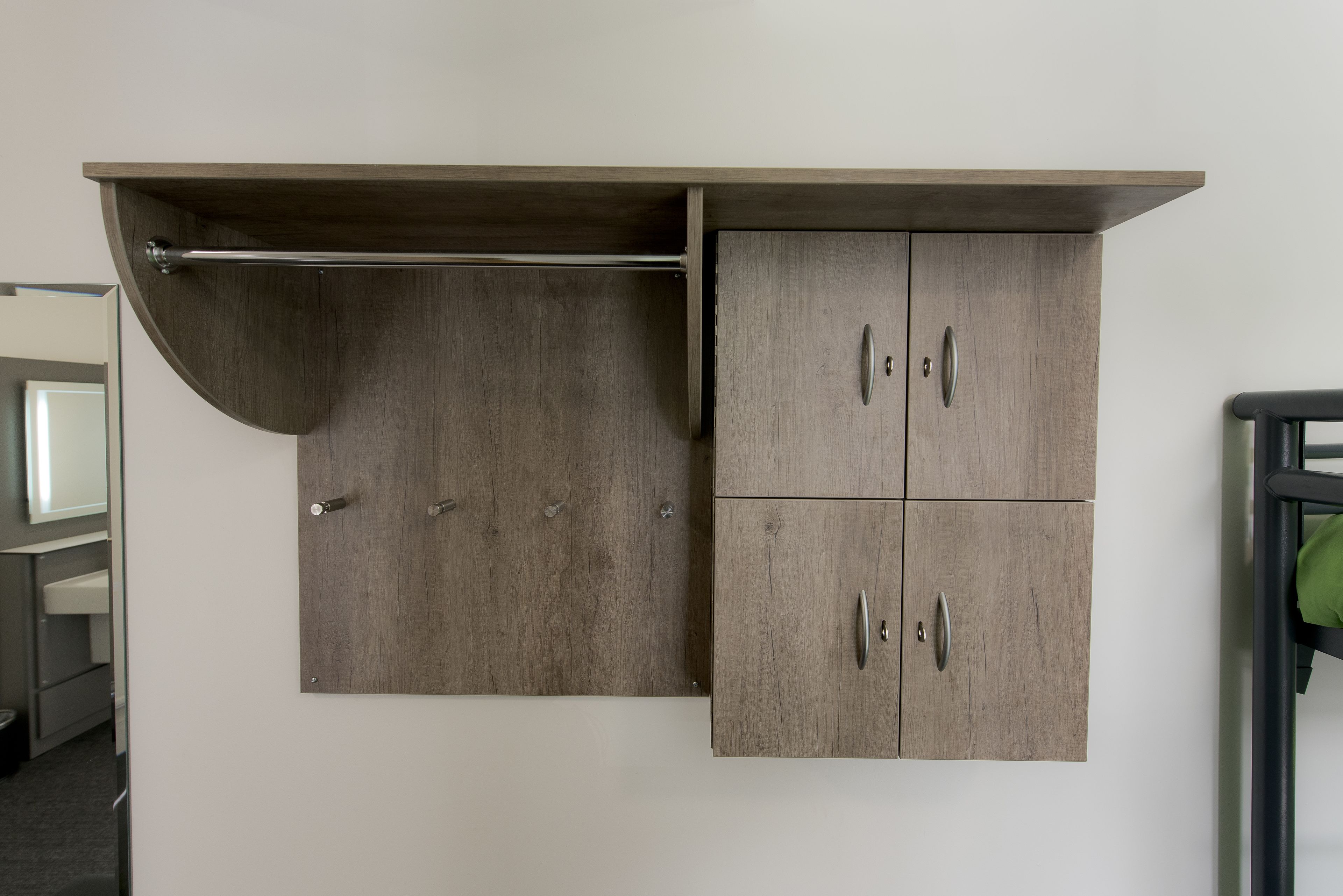 A wall-mounted wardrobe with a curved shelf and two drawers.