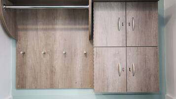 A wardrobe with a wooden finish, a hanging rod, and four doors with handles.