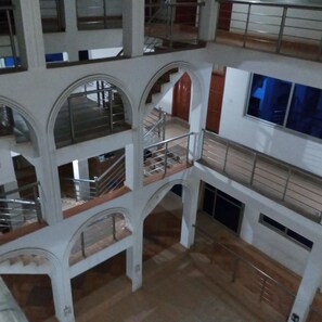 A multi-level interior with arched staircases and railings, suggesting a public or commercial building. - Pemicsa Hotel (Accra)