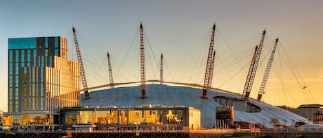 A modern stadium with a distinctive roof structure and multiple tall support towers.