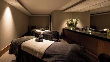 Et spa-rum med to massagestole, en reception og et spejl.