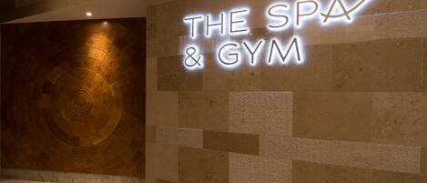 A wall with a neon sign reading "THE SPA & GYM".