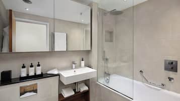 A modern bathroom with a glass-enclosed shower, a white sink, and a mirror above it.