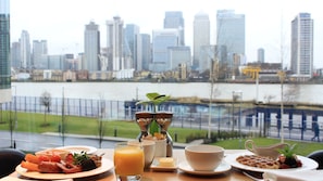 Une table de petit-déjeuner avec vue sur la ville, notamment sur une rivière et des gratte-ciel.