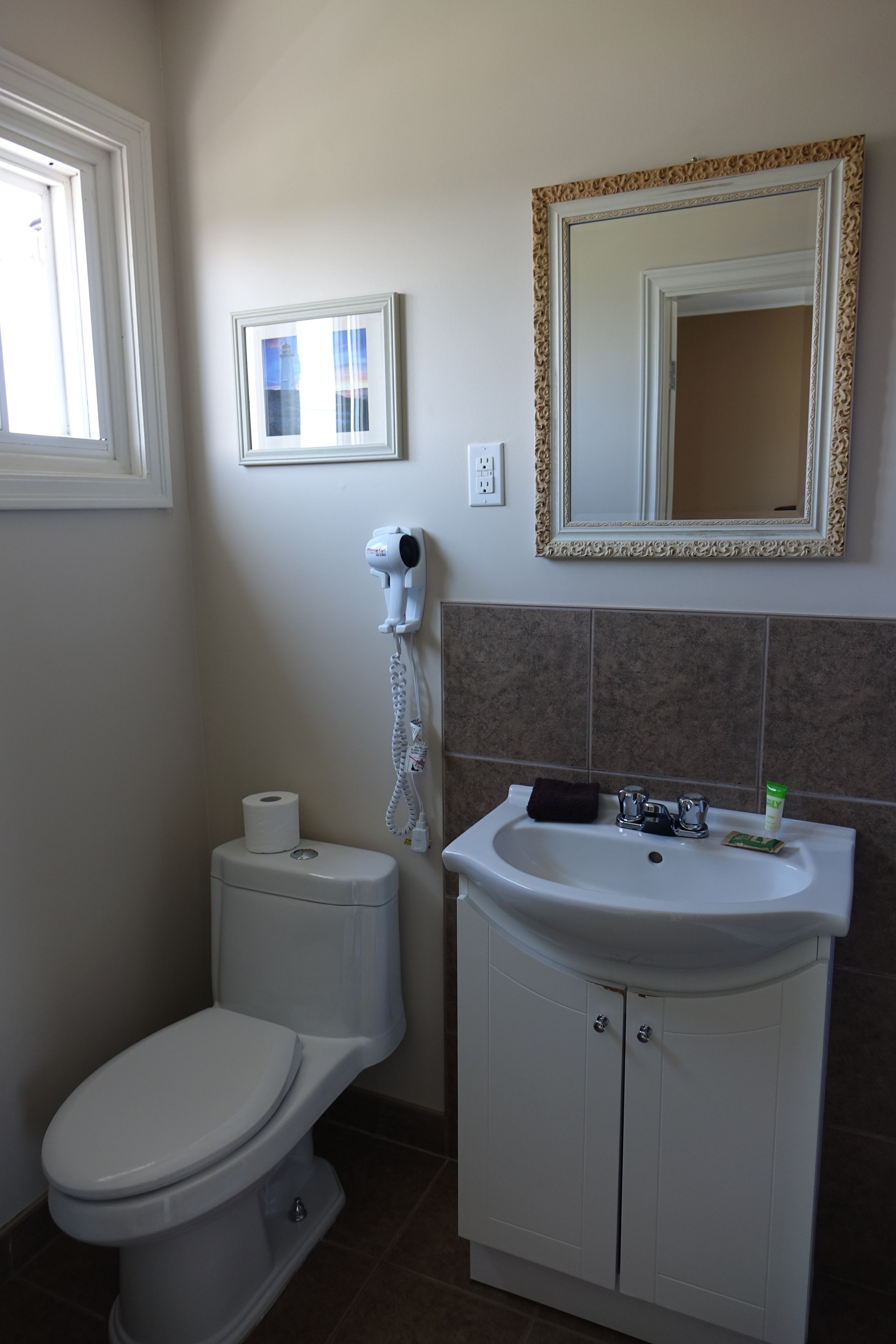 Un baño con inodoro, lavabo y espejo.