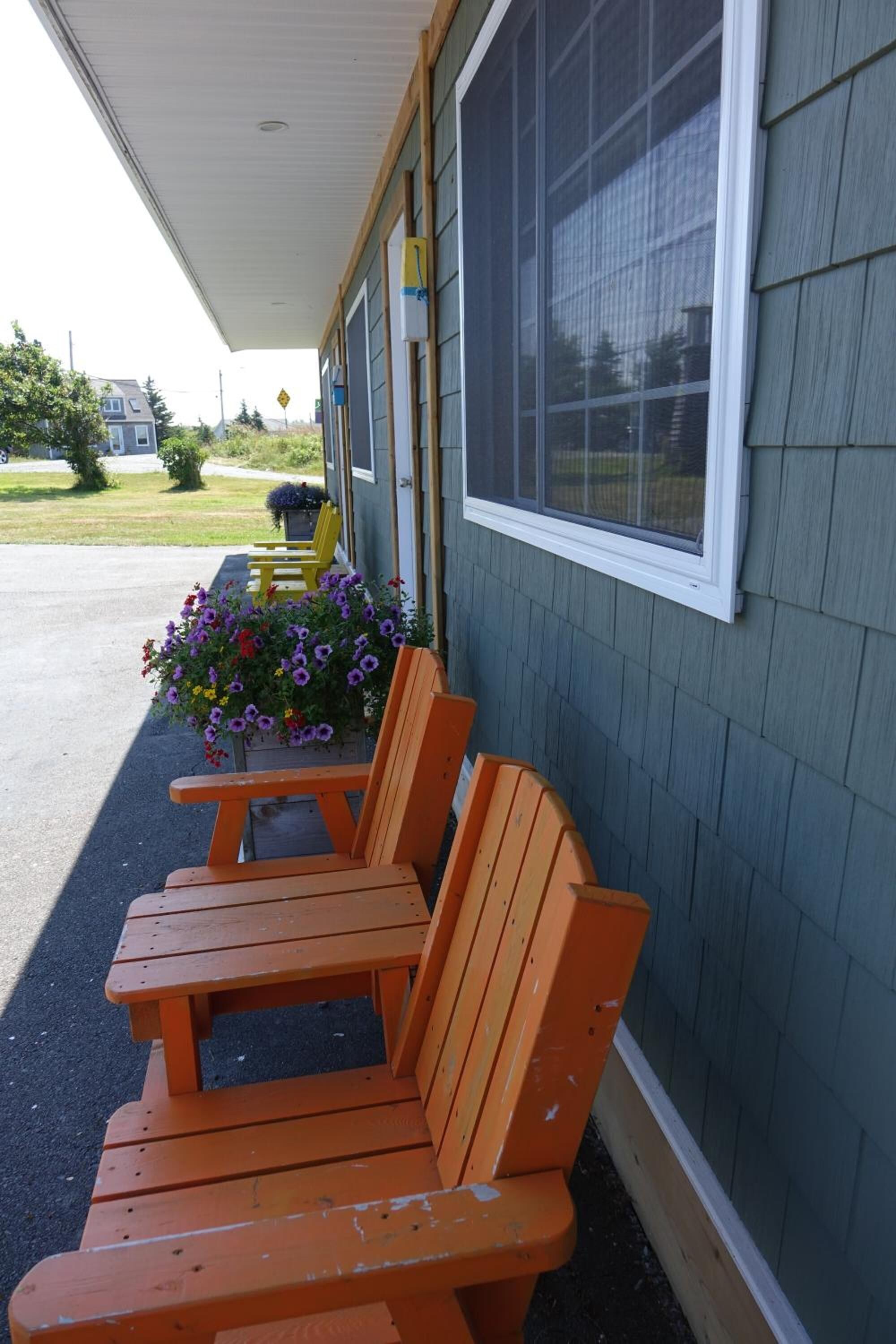 Un banc en bois et un bac à fleurs se trouvent devant un bâtiment.