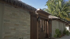 A stone building with a wooden door and a thatched roof.