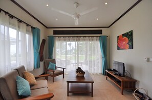 Chalet de lujo, 1 habitación, vista a la playa | Área de sala de estar | Televisión de pantalla plana de 32 pulgadas con canales por cable 