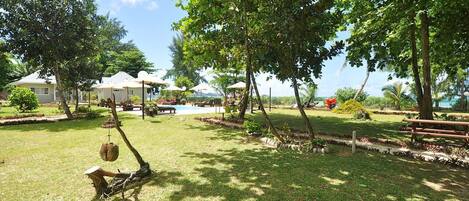 A well-maintained outdoor area with a swimming pool, picnic tables, and lounge chairs.