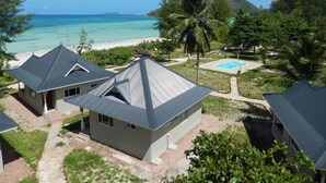 Een strandhuis met meerdere woningen, een zwembad en helder uitzicht op de oceaan.