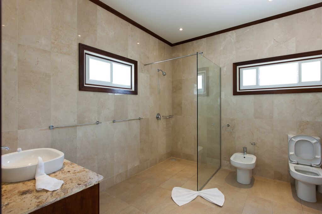 Ein modernes Badezimmer mit einer Duschkabine, einem Waschbecken mit Marmorplatte und einem Bidet.