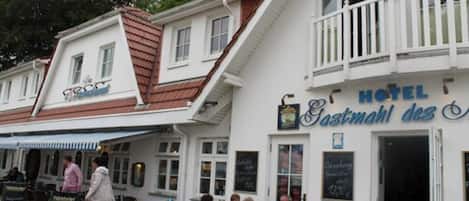 A hotel with a balcony and a sign that reads "HOTEL Gastmahl des".