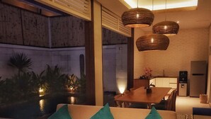 Ein modernes Wohnzimmer mit einer Couch, einem Holztisch und einem Essbereich mit Tisch und Stühlen.