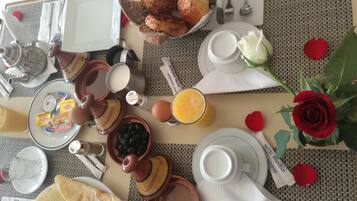 Desayuno con pan, pastelería y una rosa.