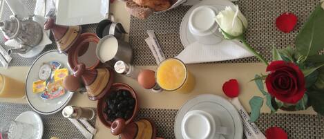 A breakfast setting with bread, pastries, and a rose.
