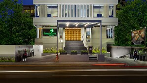 A multi-story hotel with a modern design, featuring a prominent entrance and a visible staircase leading to the lobby. - Lemon Tree Hotel Vadodra (Vadodara)