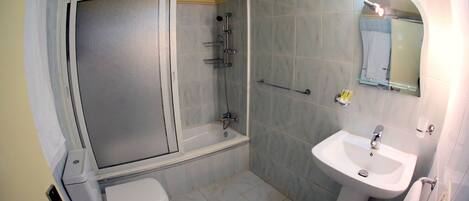 A bathroom with a shower, toilet, and sink.