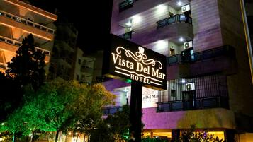 A multi-story hotel with balconies and a sign reading "Vista Del Mar Hotel".
