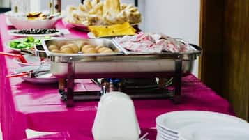 A buffet table with various food items and utensils.