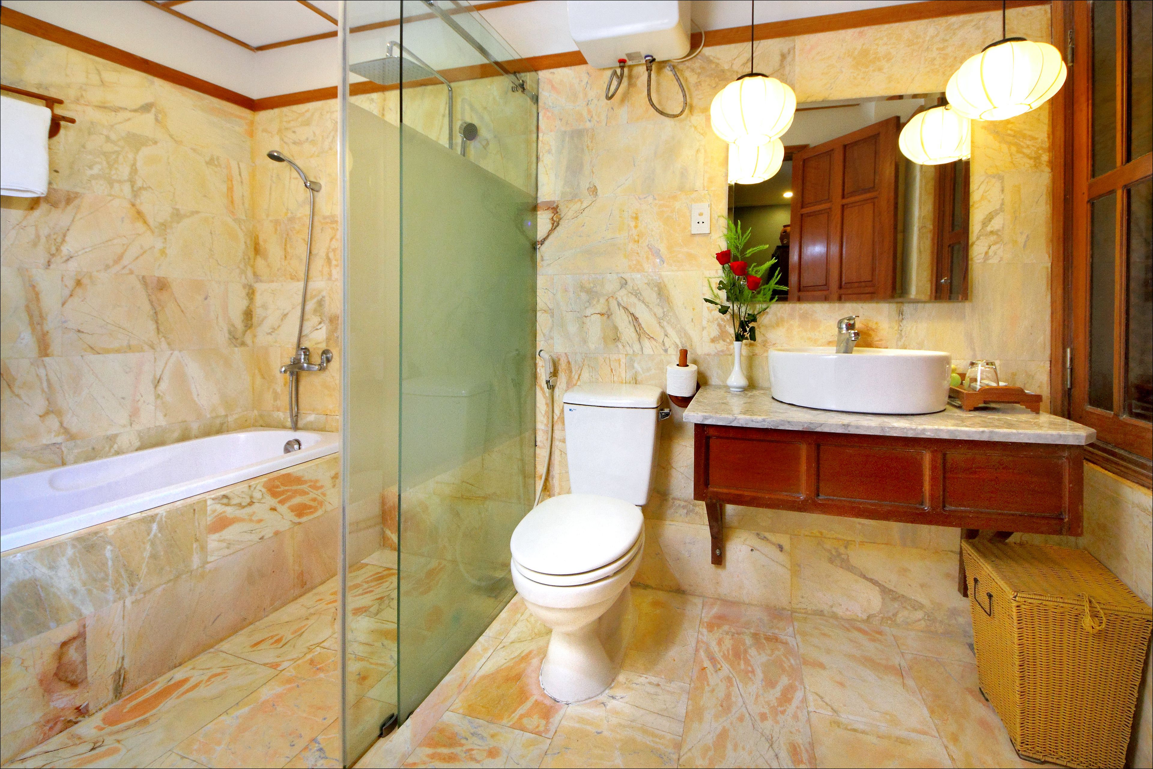 A bathroom with a bathtub, toilet, and glass-enclosed shower area.
