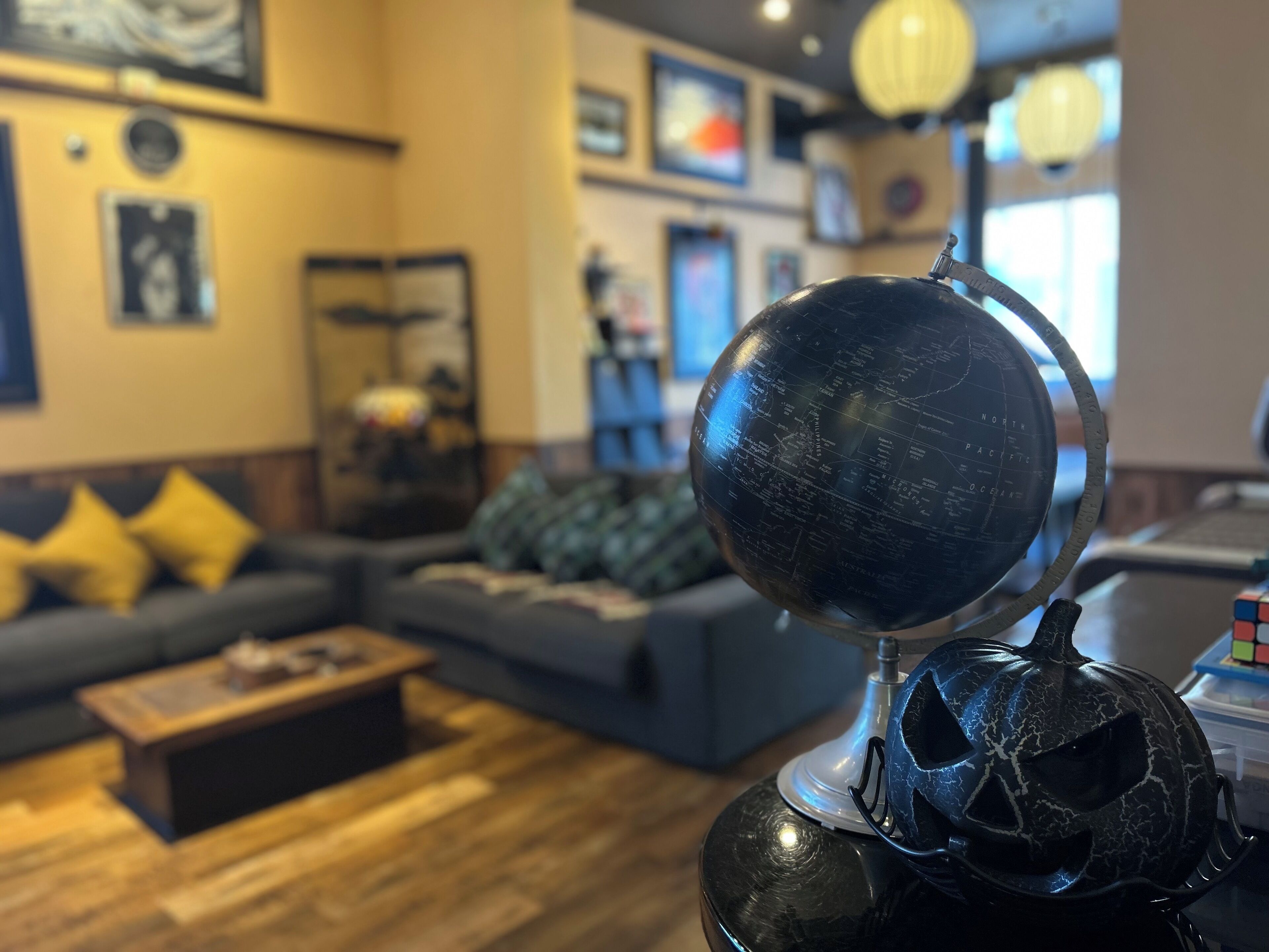 A living room with a globe, a pumpkin decoration, and a Rubik's cube on a table.