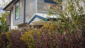 A modern house with a sloped roof and a visible window. - One of a Kind Apartments (Dickson)