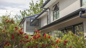 A modern two-story building with large windows and a flat roof. - One of a Kind Apartments (Dickson)