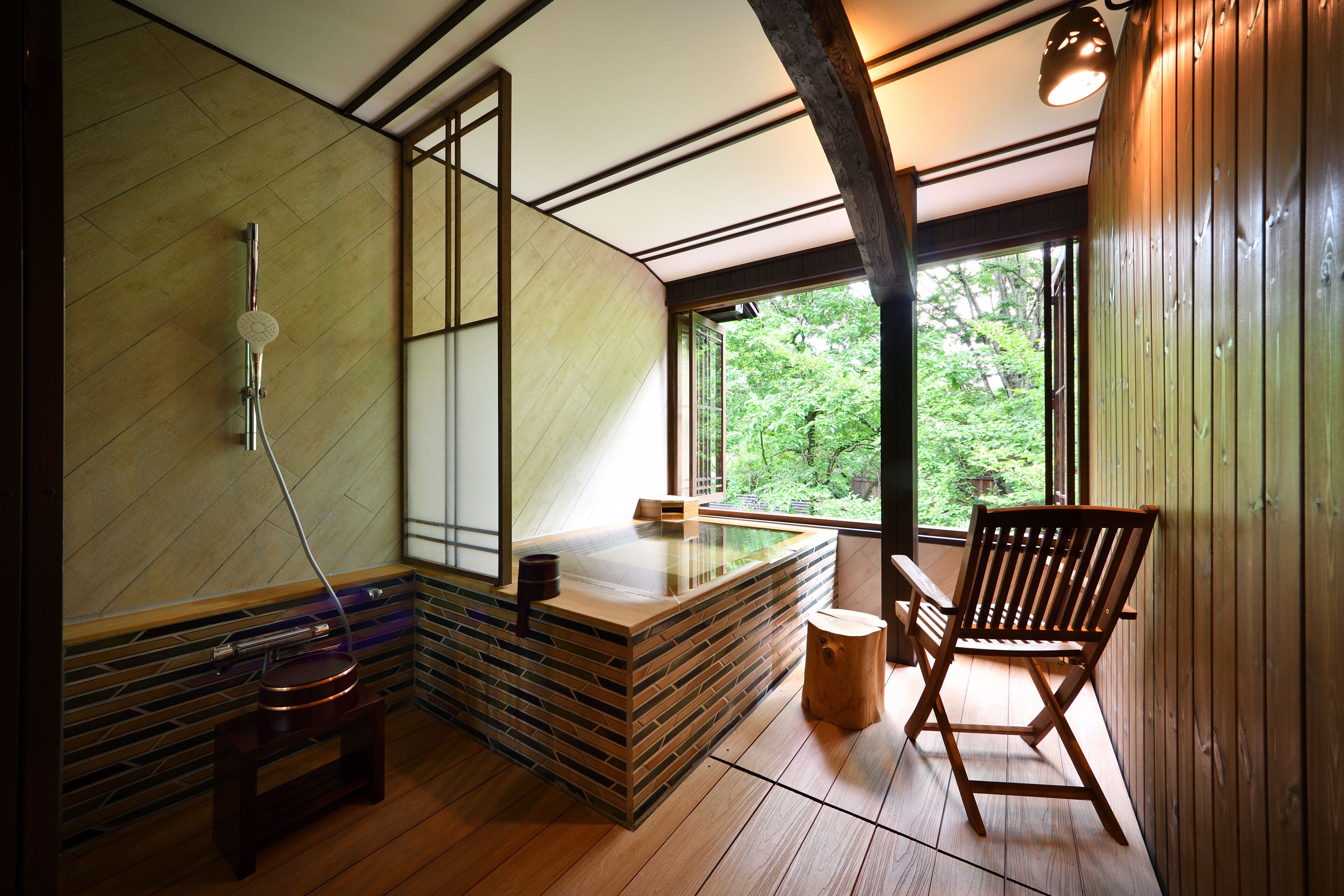 Un baño moderno con pared de piedra, un banco de madera y una silla de madera.