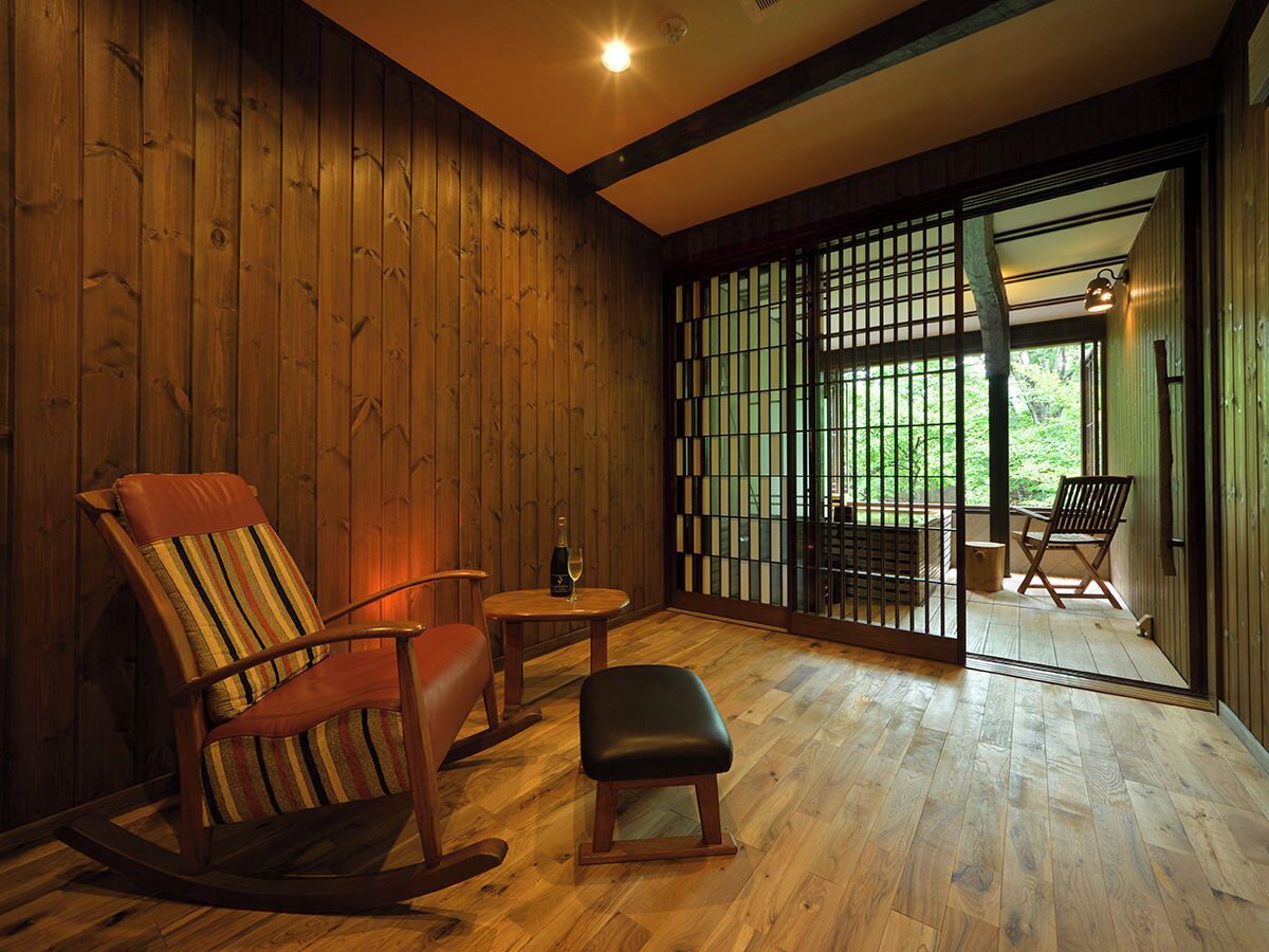 A wooden interior with a rocking chair, a small table, and a bench.
