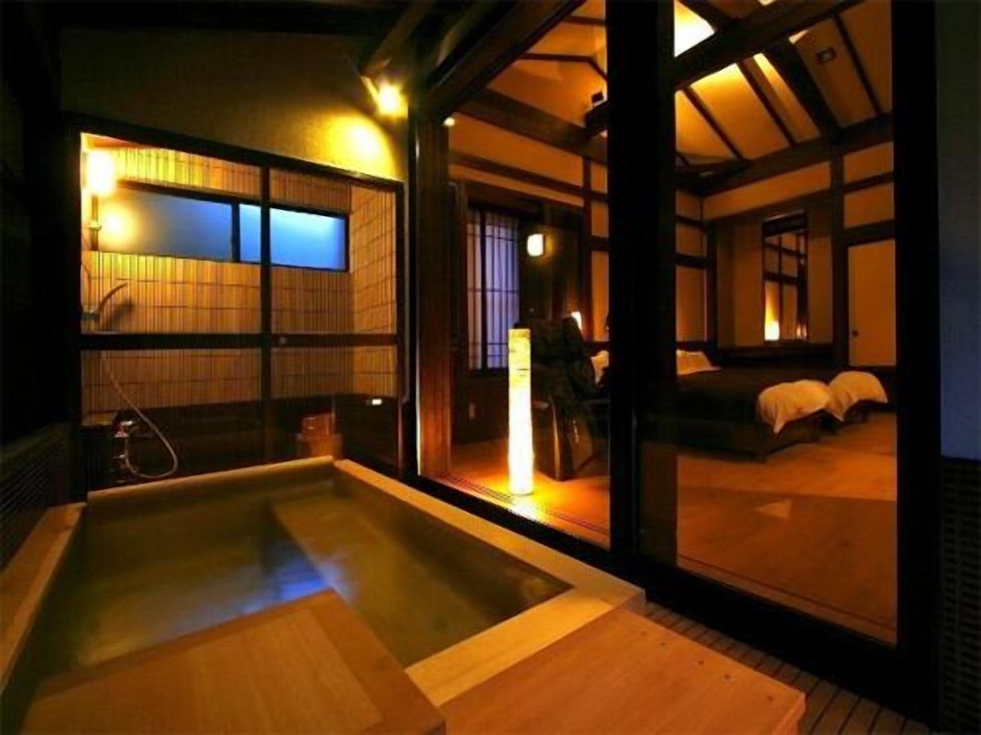 A traditional Japanese-style room with tatami flooring, a wooden bath, and sliding doors.