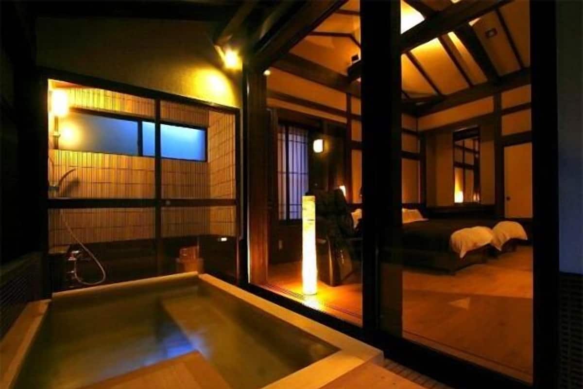 A traditional Japanese-style room with tatami flooring, a wooden bath, and sliding doors.