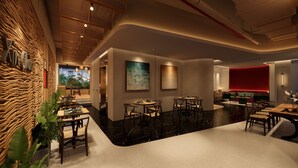 A modern interior with a dining area, a red accent wall, and a ceiling with exposed pipes. - NiK Hotel Nguyen Trai (Ho Chi Minh City)