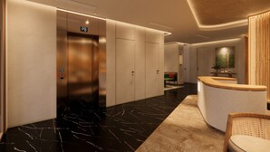 A modern hotel lobby with a reception desk, an elevator, and a seating area. - NiK Hotel Nguyen Trai (Ho Chi Minh City)