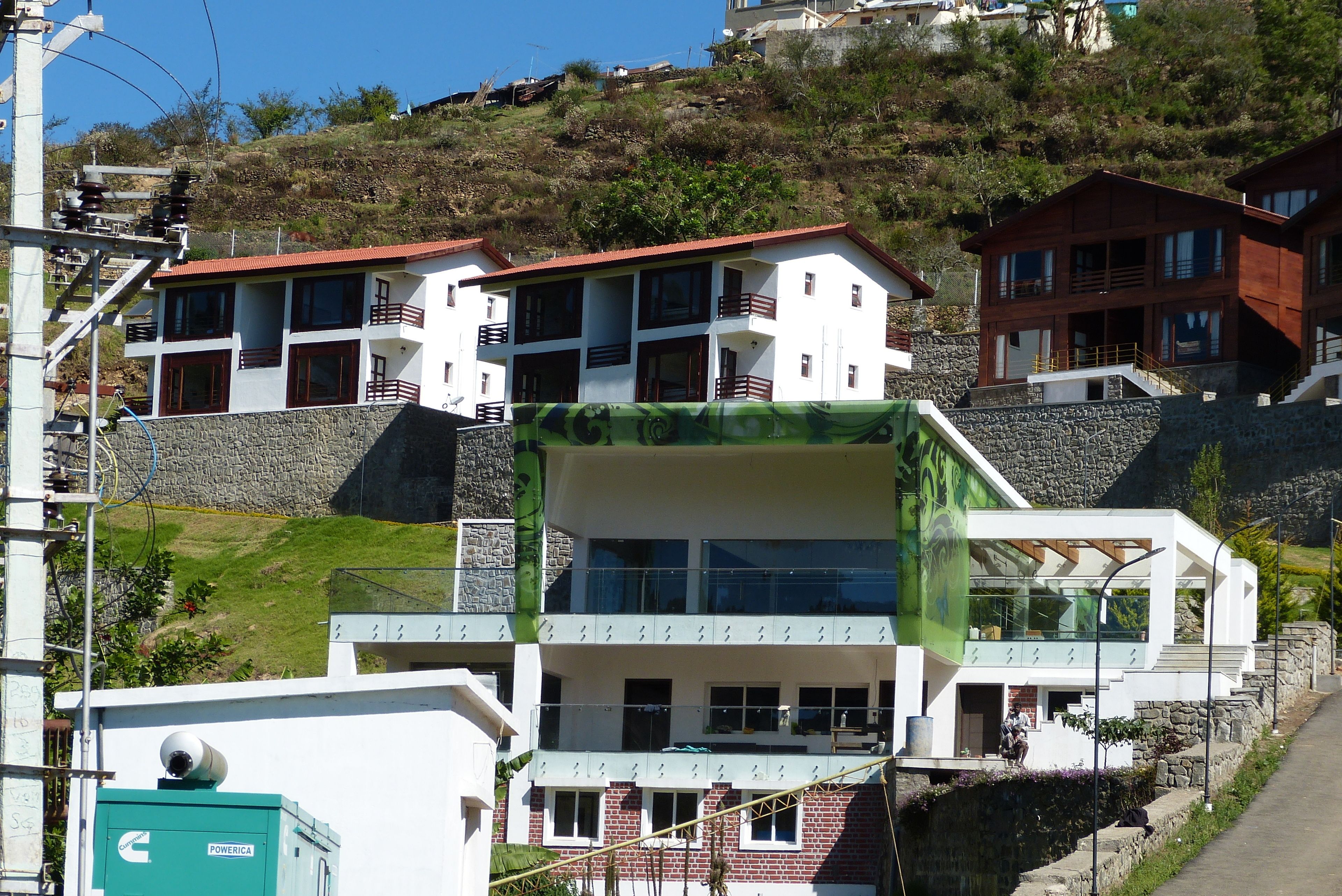 A modern building with multiple floors, large windows, and a stone base.
