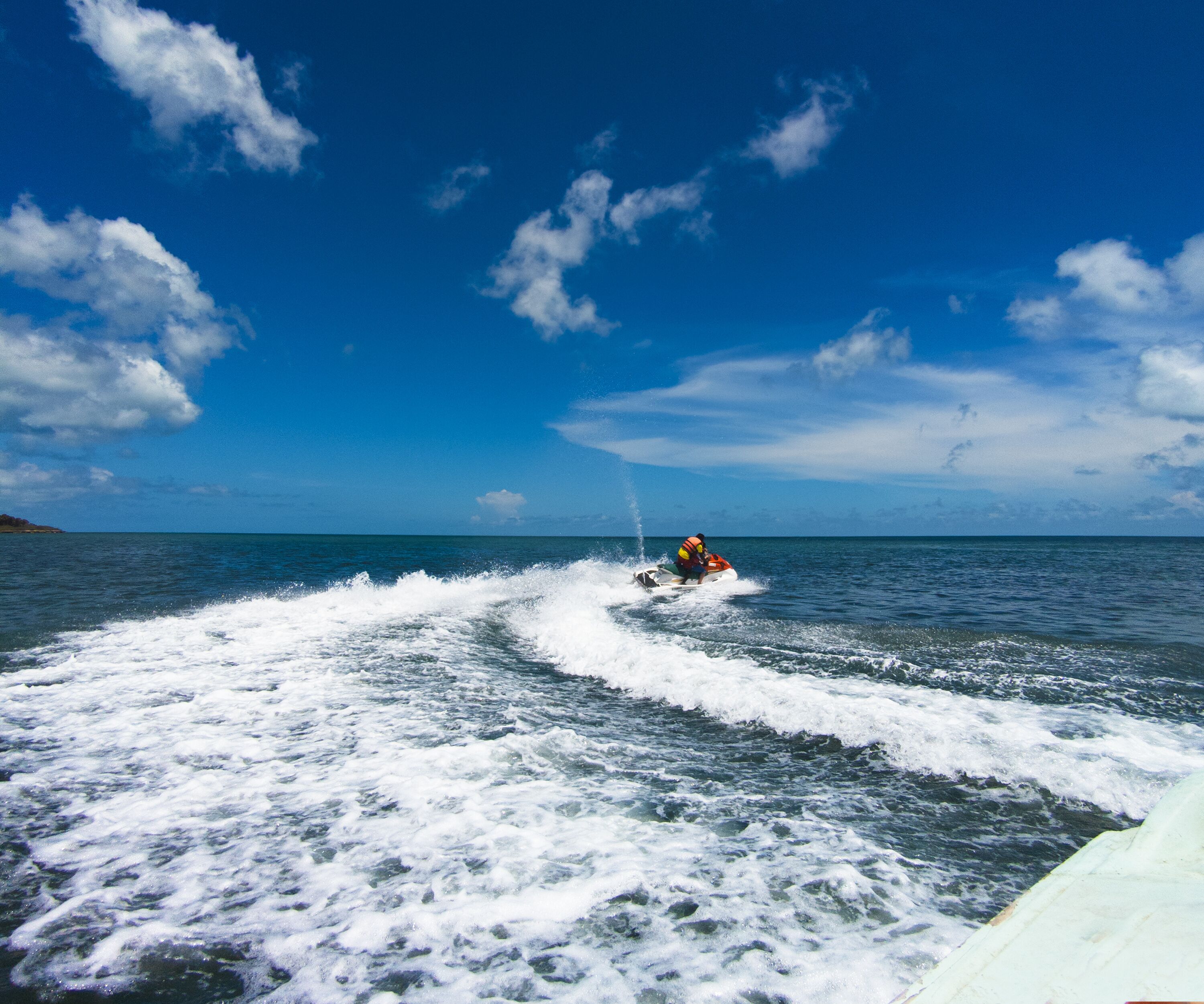 A jet ski on the water with a wake behind it.