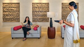A modern lobby with a sofa, a decorative wall, and a lamp. - Daiwik Hotels Rameswaram (Rameshwaram)