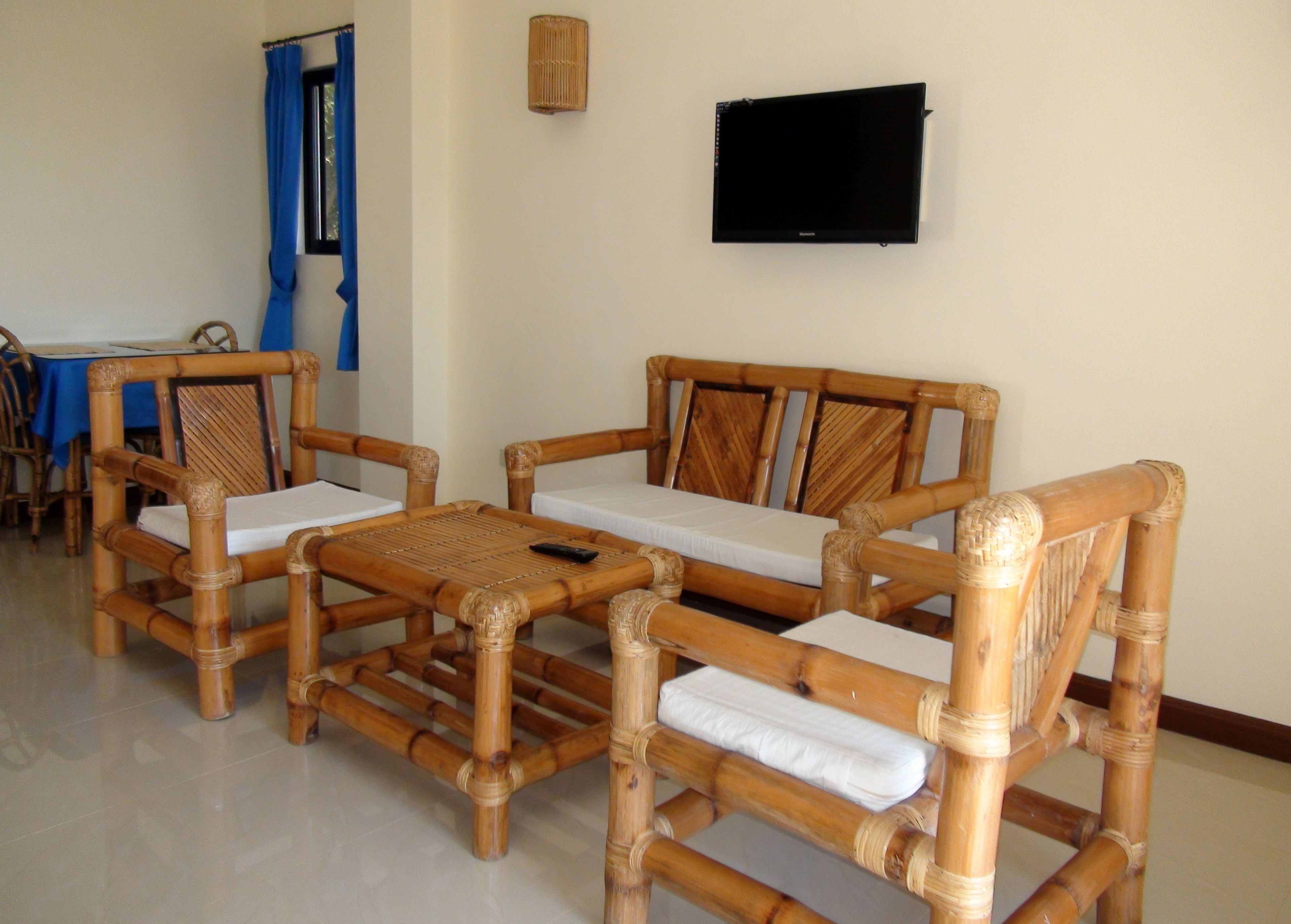Una habitación con un conjunto de sofás, un televisor y una mesa con sillas.
