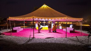 Et telt med et pink tæppe og en scene til forestillinger.