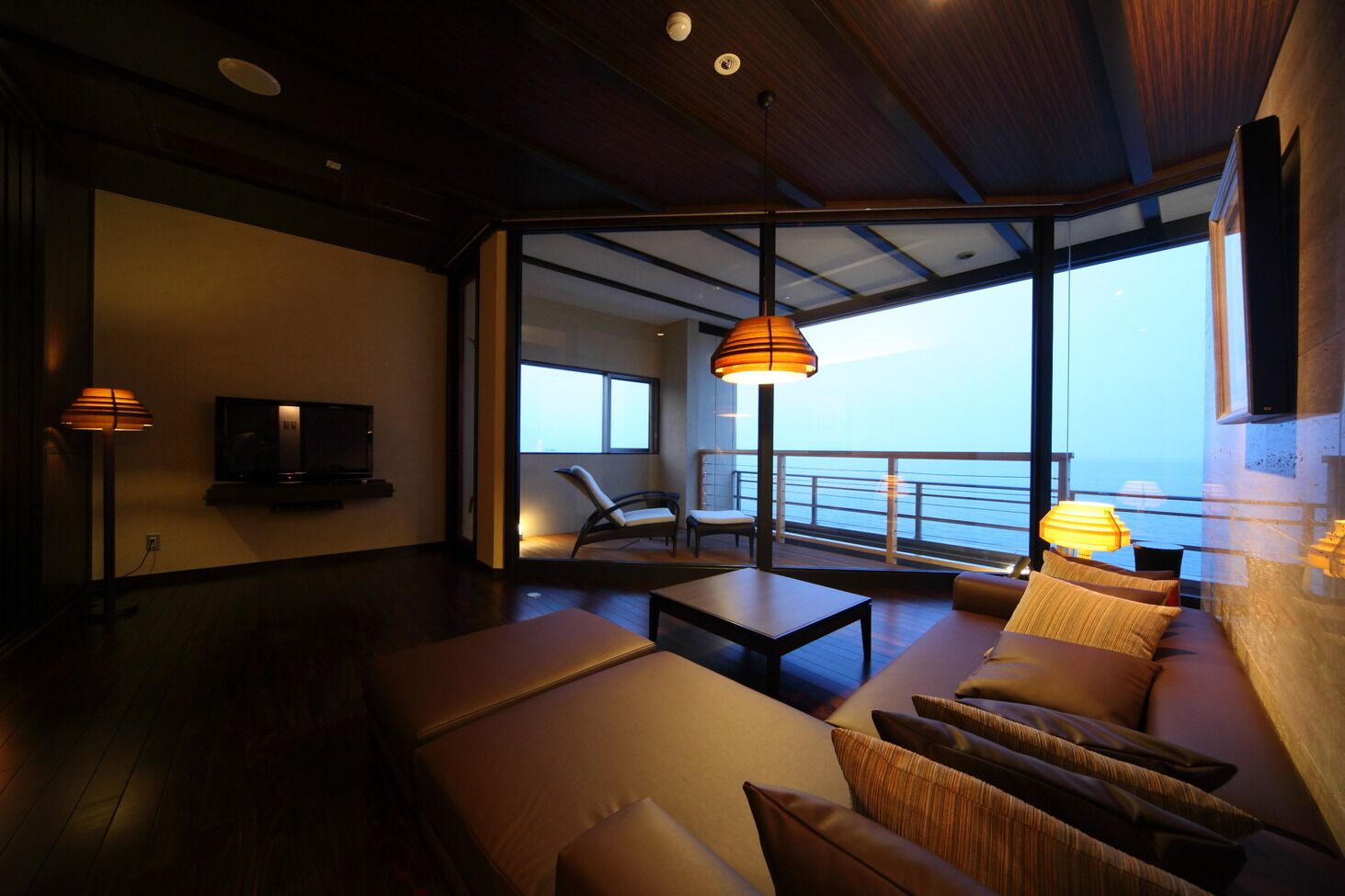 Een moderne woonkamer met een bank, een televisie en een balkon met uitzicht.