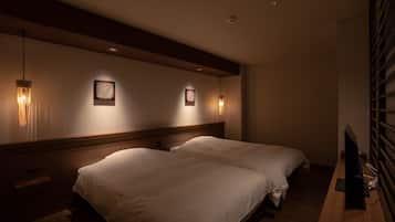 A hotel room with two beds, a wooden headboard, wall-mounted artwork, and a television on a wooden desk.