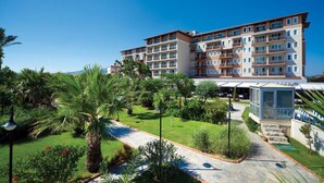 Un hôtel à plusieurs étages doté d’une cour intérieure, entourée d’une végétation luxuriante et de palmiers.