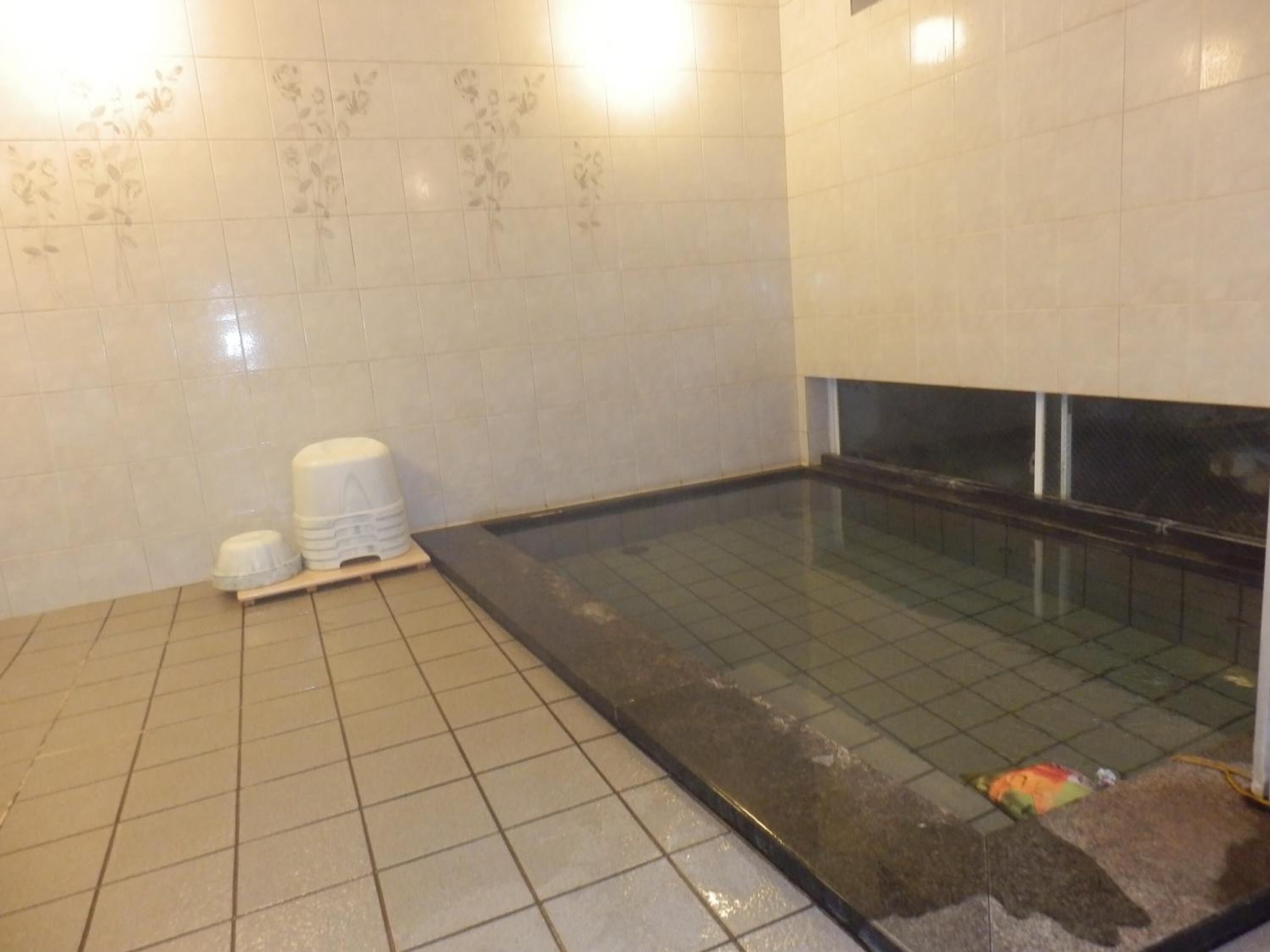 Un baño con piso de cerámica, una bañera y un inodoro.